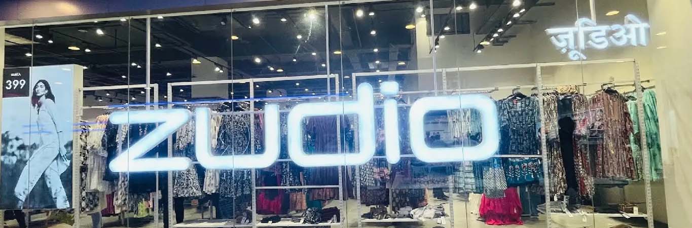 Mall clothing storefront with glass windows and hanging garments