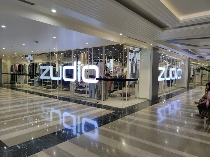 Clothing storefront with illuminated signage in a mall